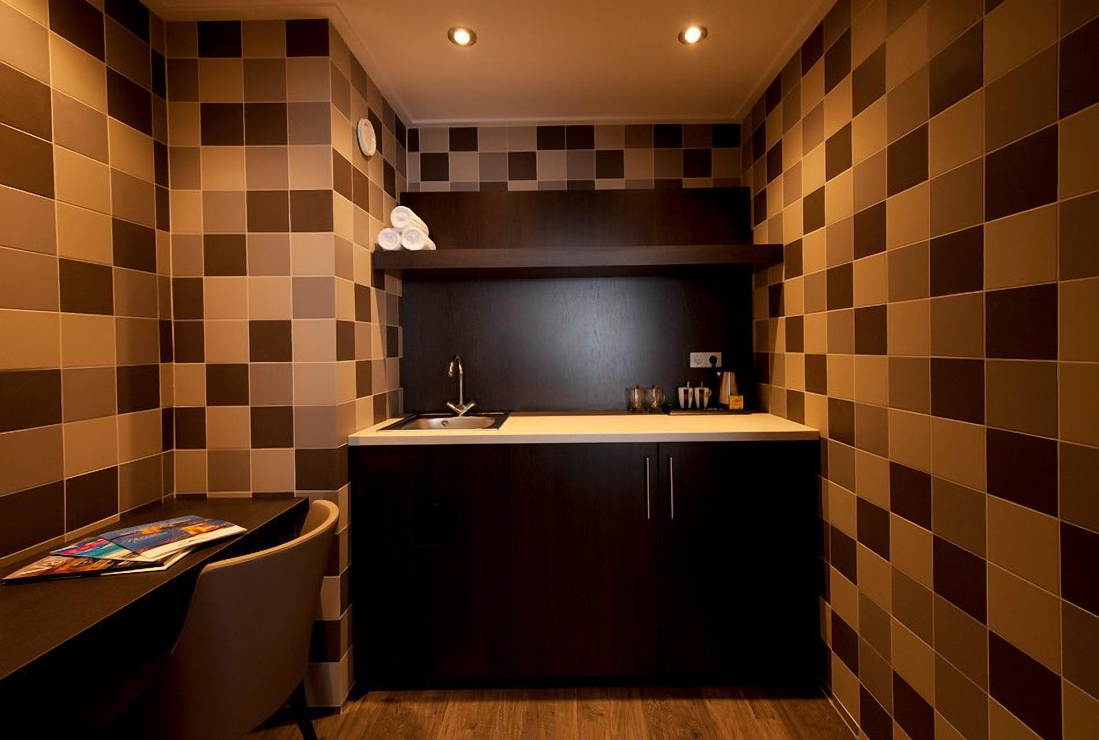 A compact kitchen with a dark countertop, a sink, and a small cabinet.