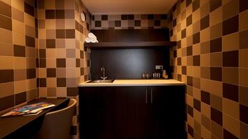 A compact kitchen with a dark countertop, a sink, and a small cabinet.