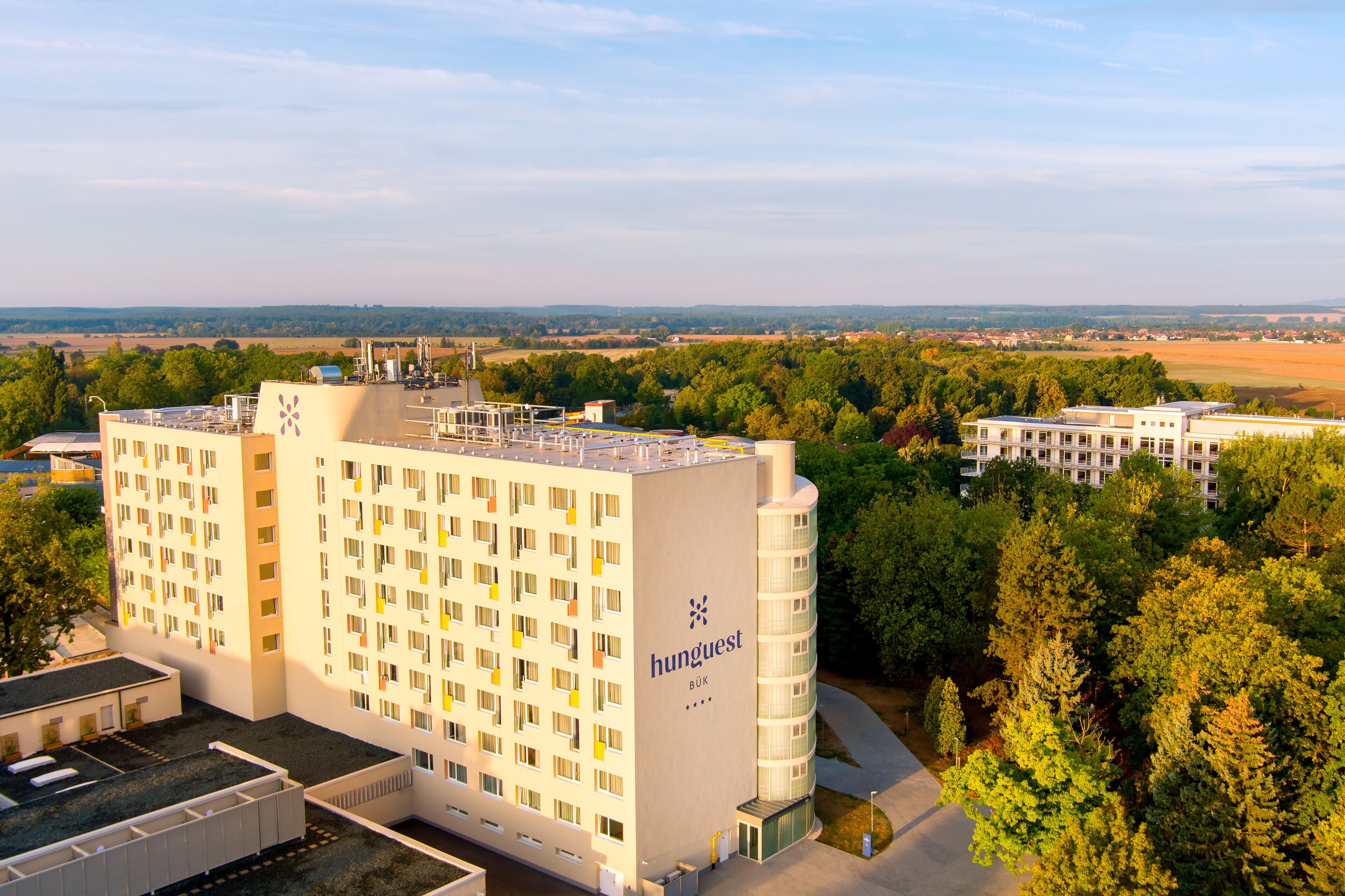 A multi-story hotel with a modern design, featuring a prominent 'hunguest' logo on the side.