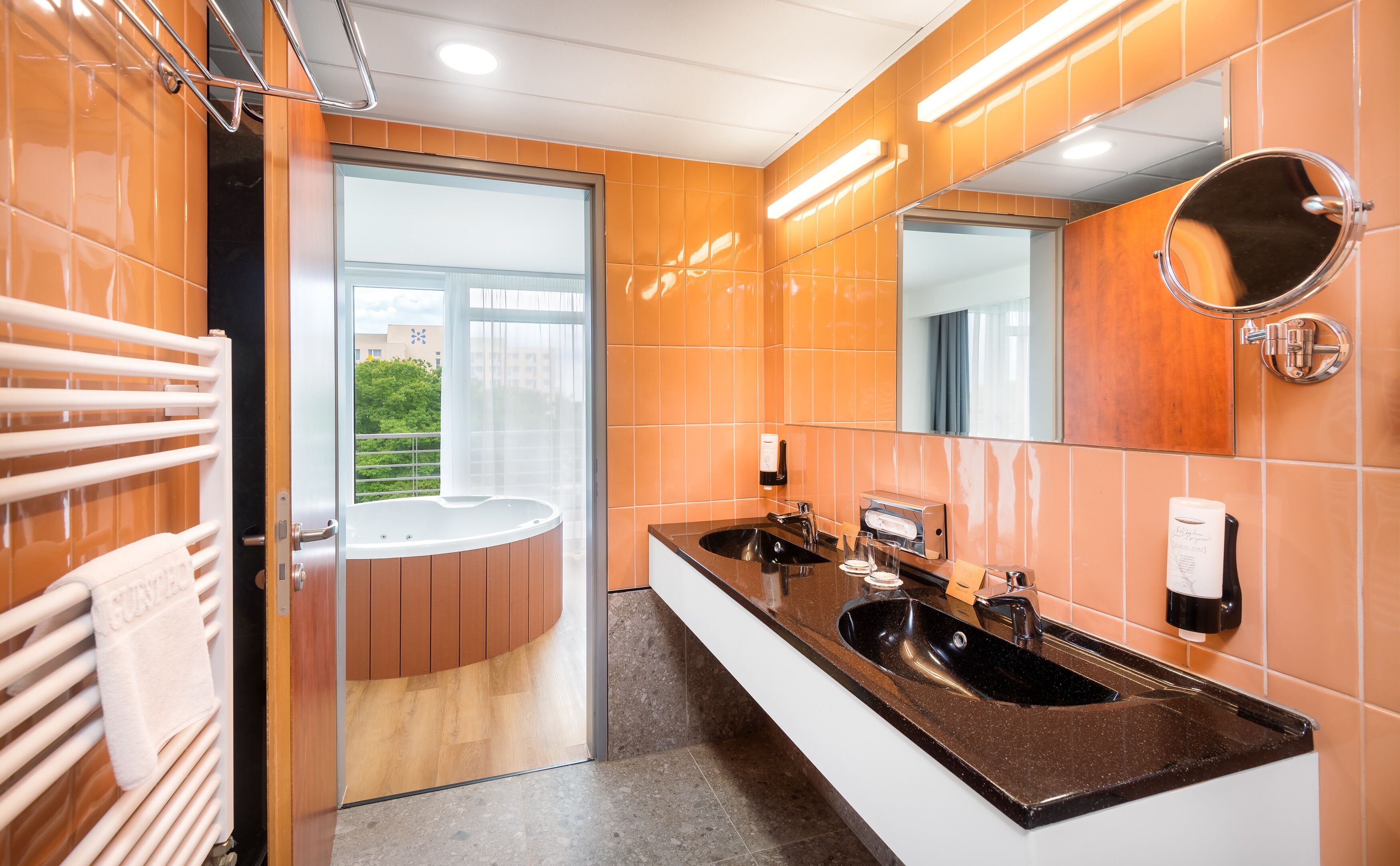 Ein modernes Badezimmer mit zwei Waschbecken, einem großen Spiegel und einer Duschkabine.
