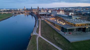 Ein Luftbild einer Flusslandschaft mit einer modernen Gebäude mit Glasfassade und einem Fußgängerweg am Flussufer.