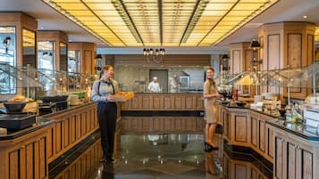 Un vestíbulo de hotel con un área central de servicio, paneles de madera y un piso pulido.