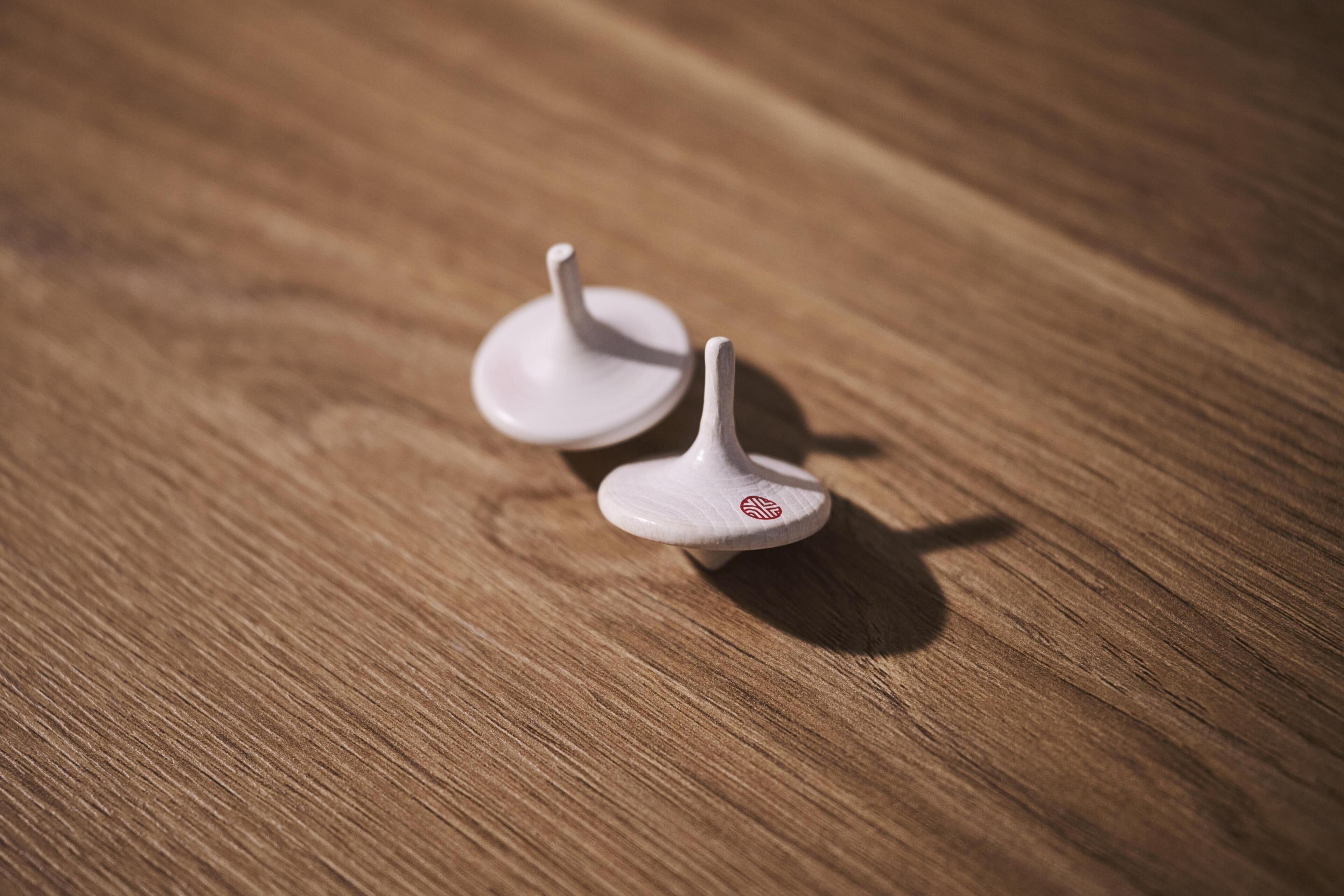 Two white objects with a logo on a wooden surface.