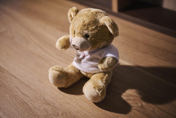 A teddy bear on a wooden floor.