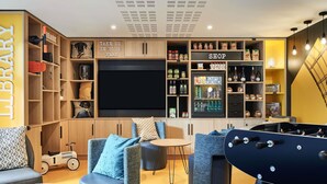 Een moderne woonkamer met een flatscreen-tv, een zithoek en een speeltafel.