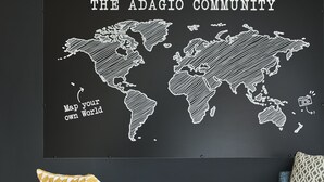 Een muur met een wereldkaart en de tekst 'THE ADAGIO COMMUNITY' en 'Verken jouw eigen wereld'.