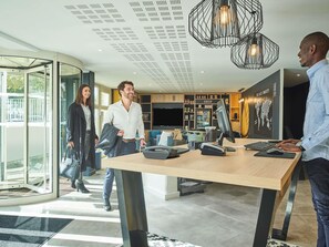 Een modern interieur met een receptiebalie, een wereldkaart aan de muur en een glazen deur.