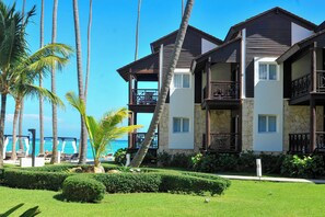 A resort with multiple-story buildings, balconies, and a view of the ocean.