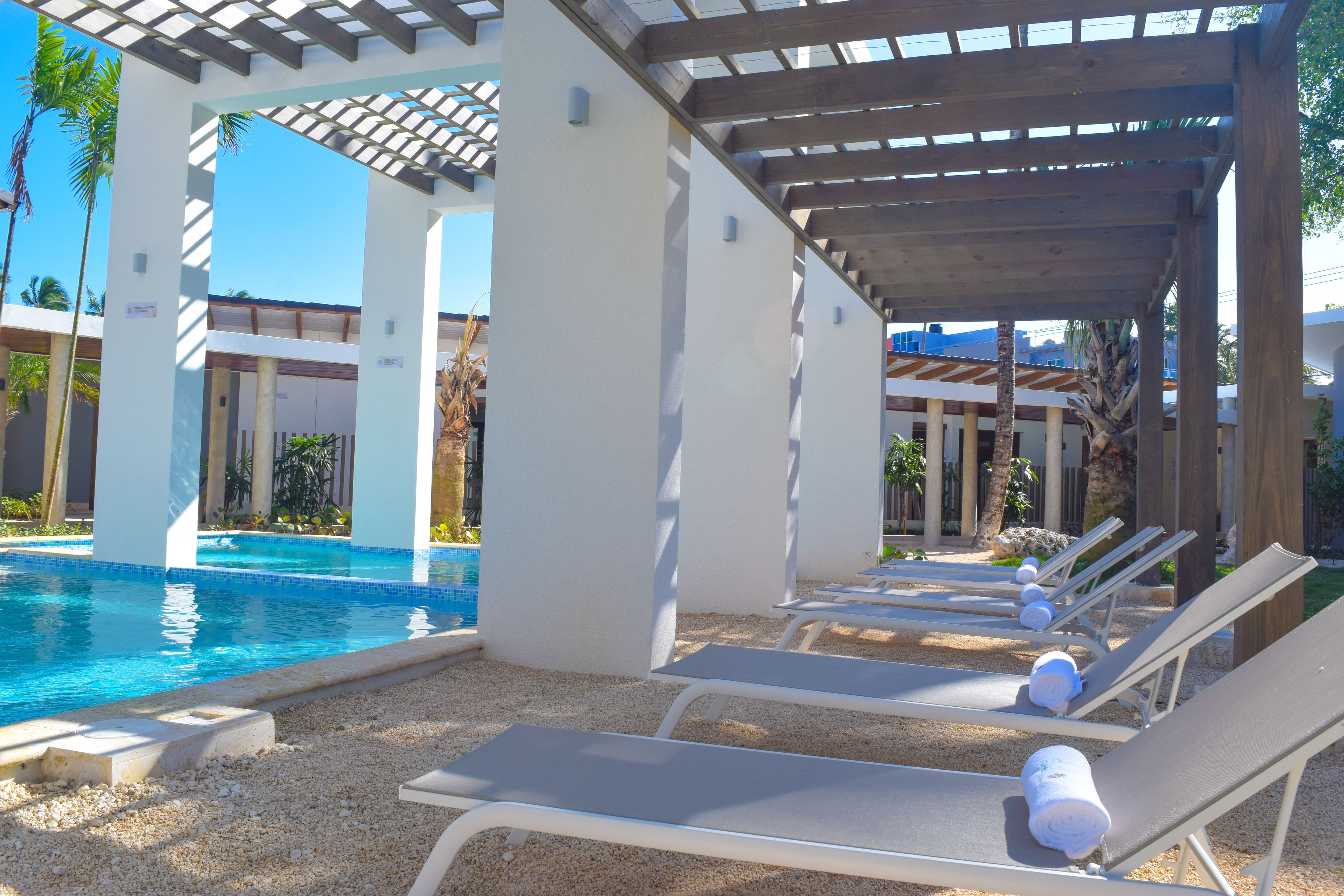 A pool area with lounge chairs and a pergola structure.