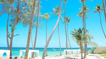 Playa privada, arena blanca, sillas reclinables de playa