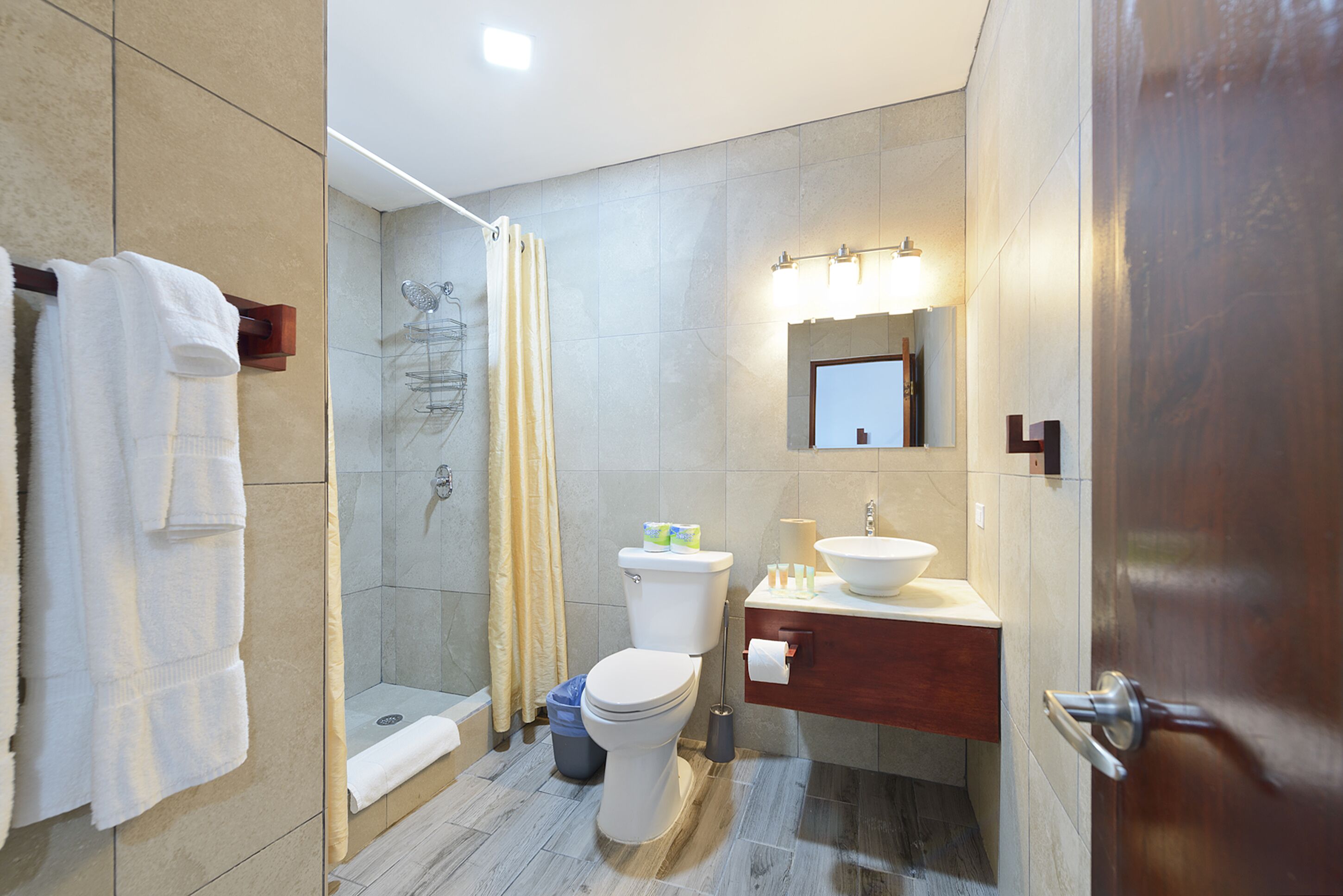 A modern bathroom with a shower, toilet, and vanity.