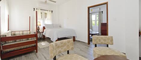 A bedroom with a bed, a wooden bench, and a table with chairs.