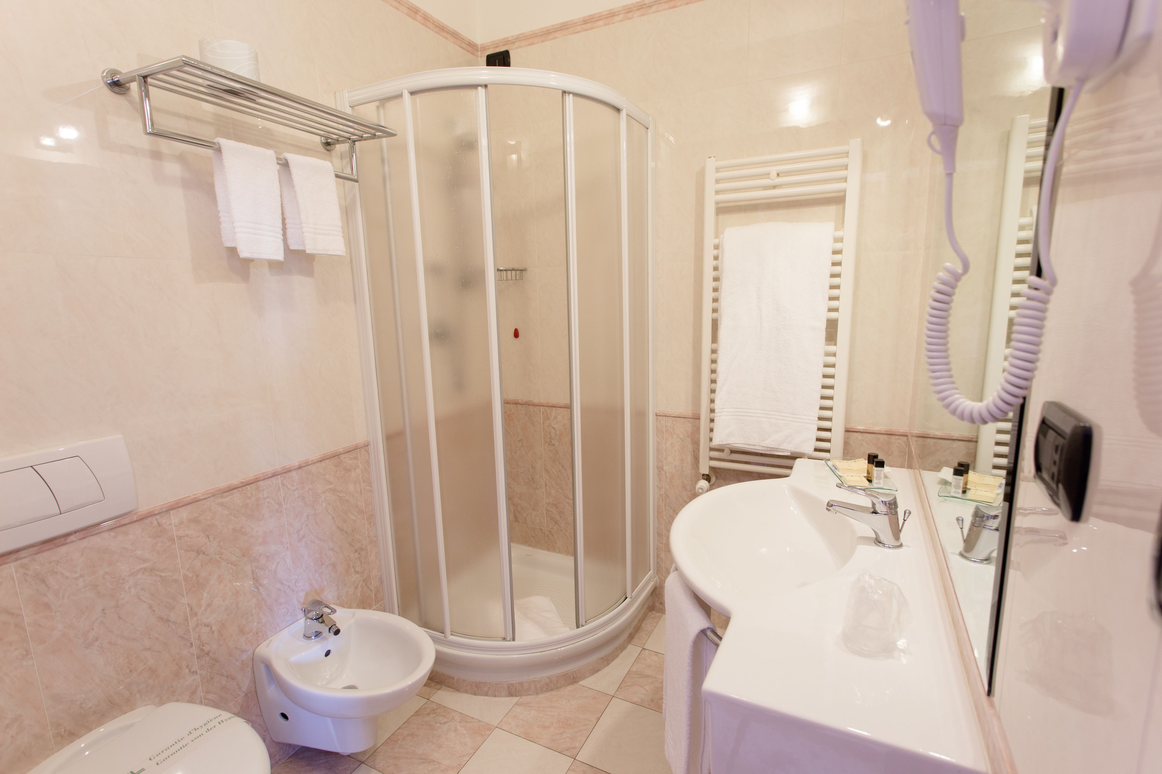 Een moderne badkamer met een douchecabine van glas, een wastafel en een toilet.