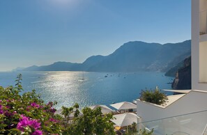 A coastal view with a clear sky, a calm sea, and distant mountains. - Casa Angelina (Praiano)