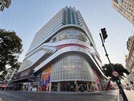 Un edificio moderno con fachada curva, grandes ventanales y letreros de restaurante McDonald's.