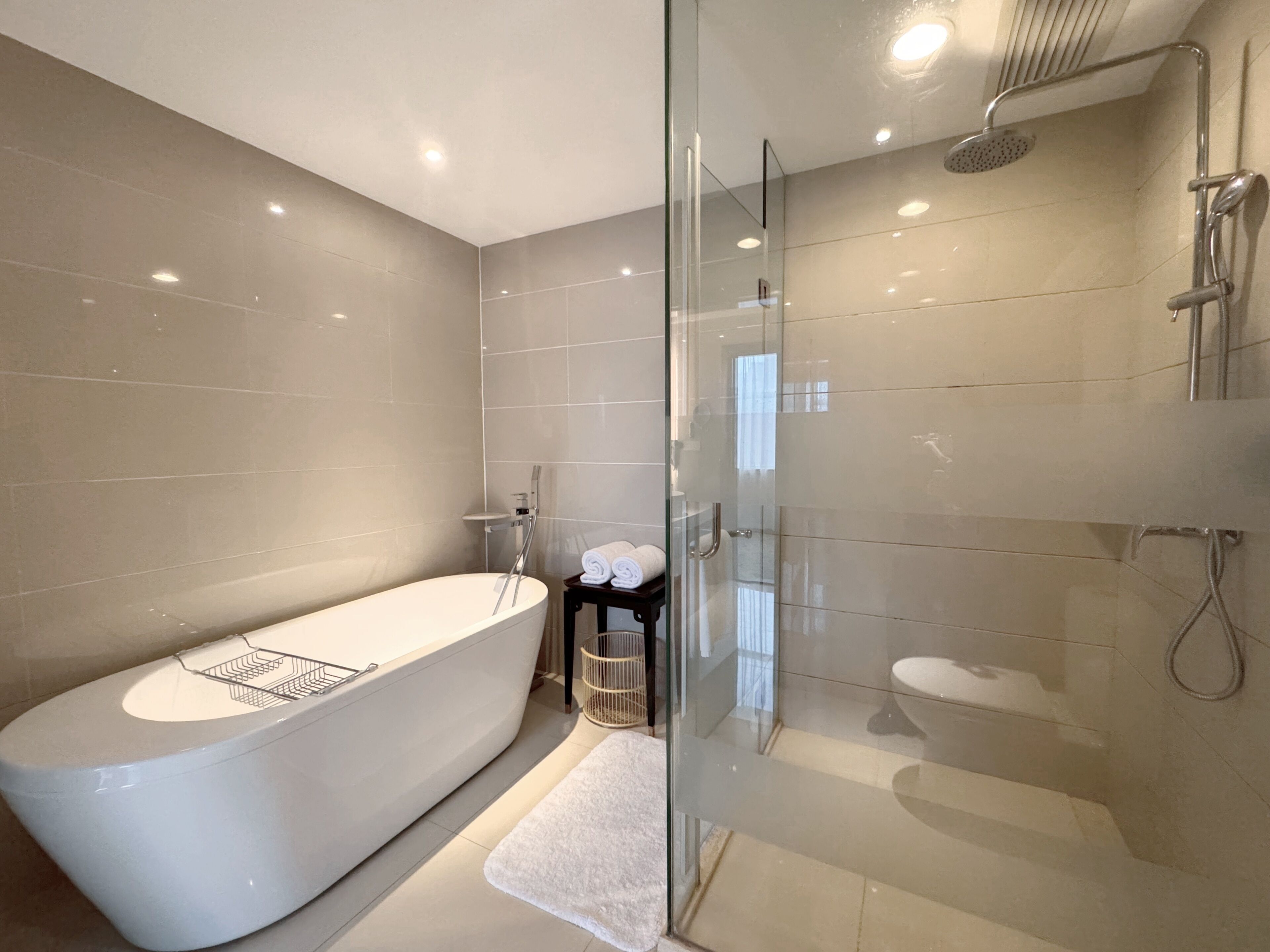 A modern bathroom with a freestanding bathtub, a glass-enclosed shower, and a toilet.