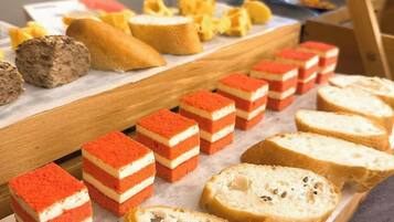 Eine Auswahl an Speisen, darunter Schichtkuchen, Brot und Gebäck.