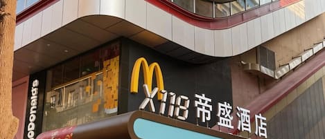 A McDonald's restaurant with a modern architectural design, featuring a curved facade and a prominent McDonald's logo.