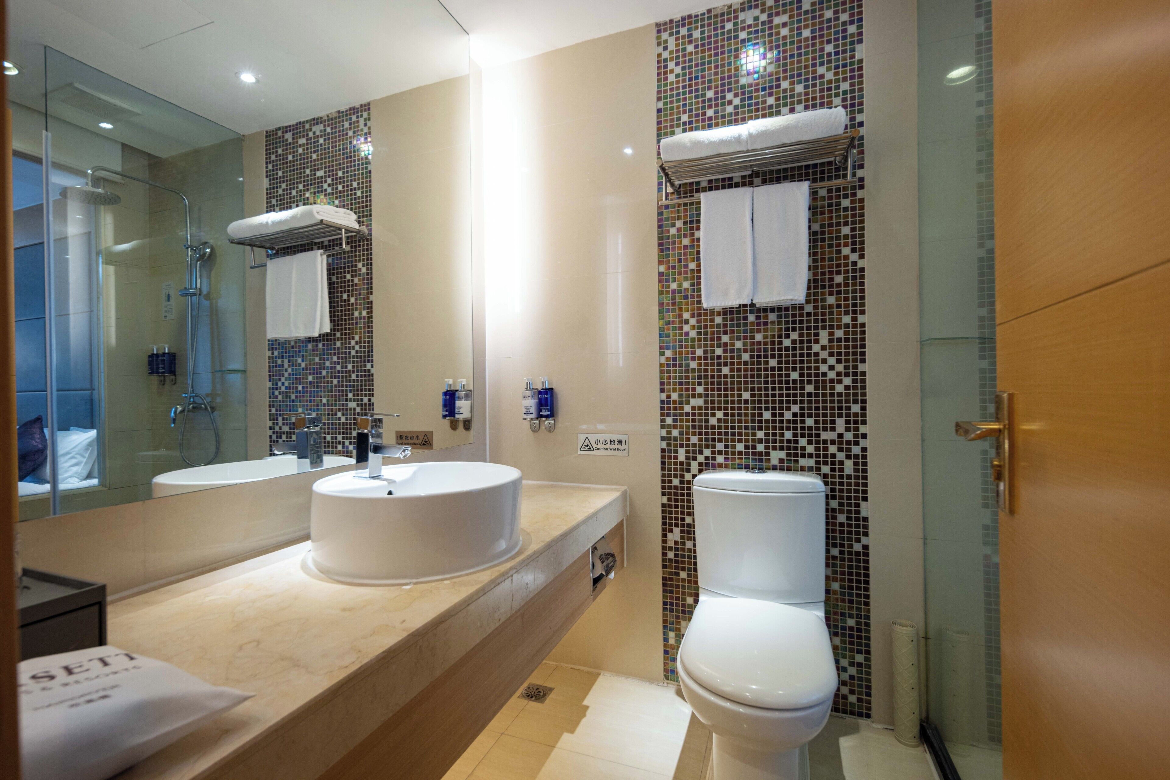 Un baño moderno con dos lavamanos, inodoro y zona de ducha.