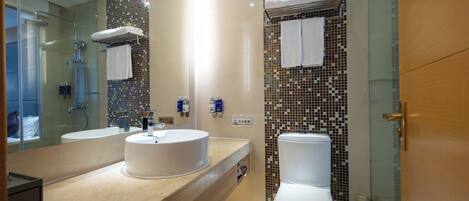Un baño moderno con dos lavamanos, inodoro y zona de ducha.