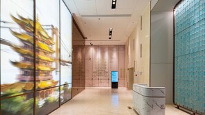 Un hall d’entrée moderne doté d’un écran numérique, d’un sol en marbre et d’un comptoir d’accueil.