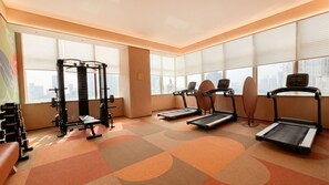 A gym with treadmills, a squat rack, and weight benches.