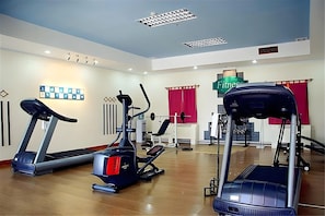 Una palestra attrezzata con tapis roulant, ellittiche e una cyclette.
