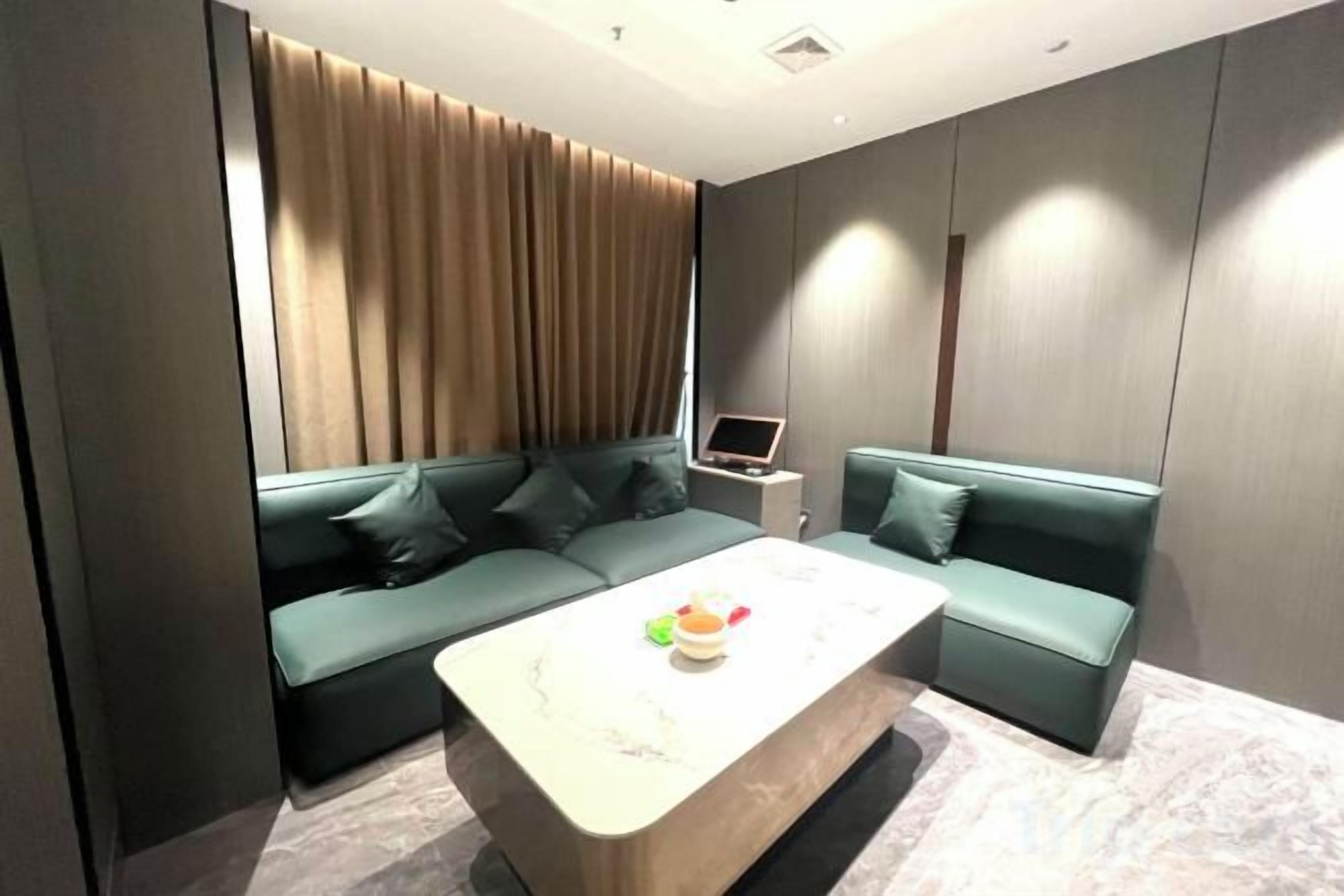 A modern room with a sectional sofa, a small table, and a laptop on a side table.