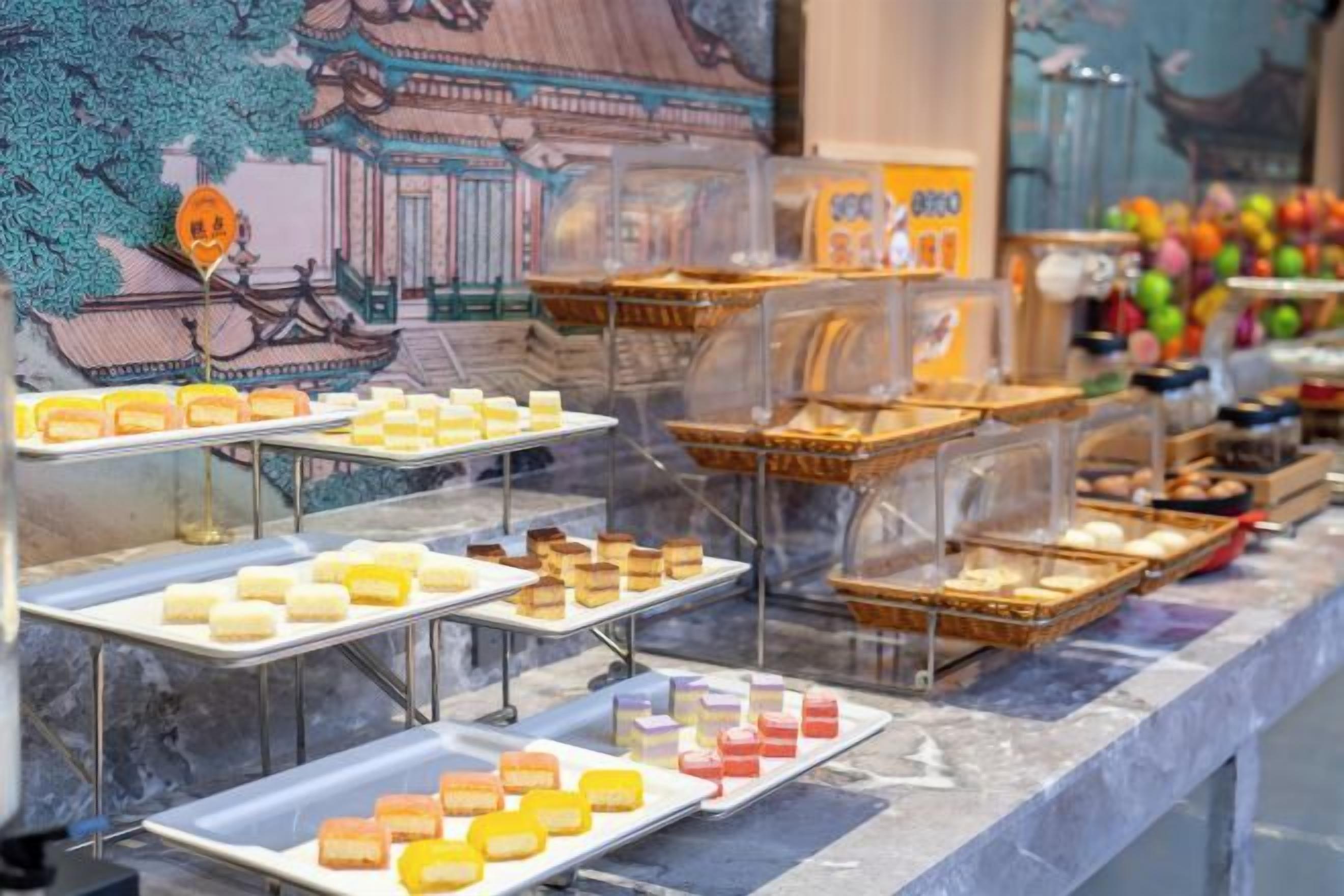 Une vitrine contenant divers produits alimentaires, notamment des pâtisseries et des desserts, disposés sur plusieurs étagères.