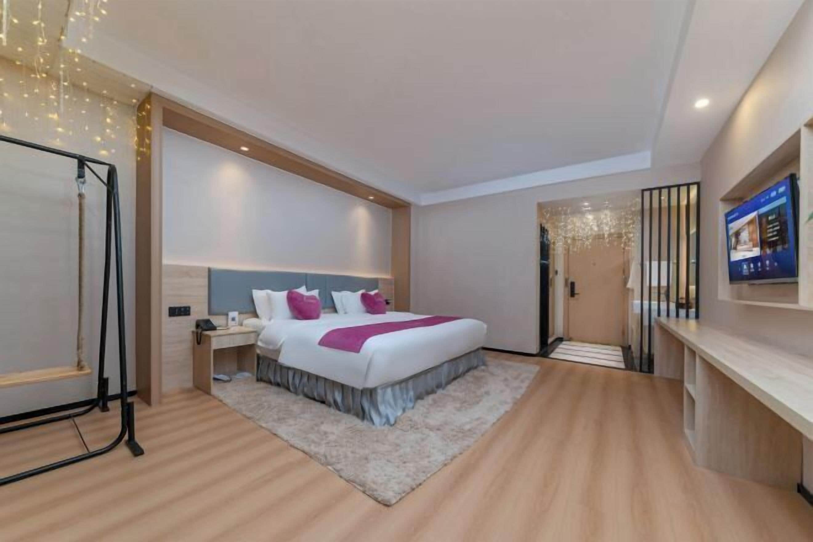 Een moderne hotelkamer met een groot bed, nachtkastjes, een bureau en een televisie.