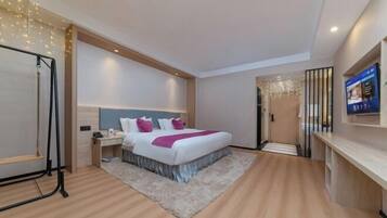 Een moderne hotelkamer met een groot bed, nachtkastjes, een bureau en een televisie.