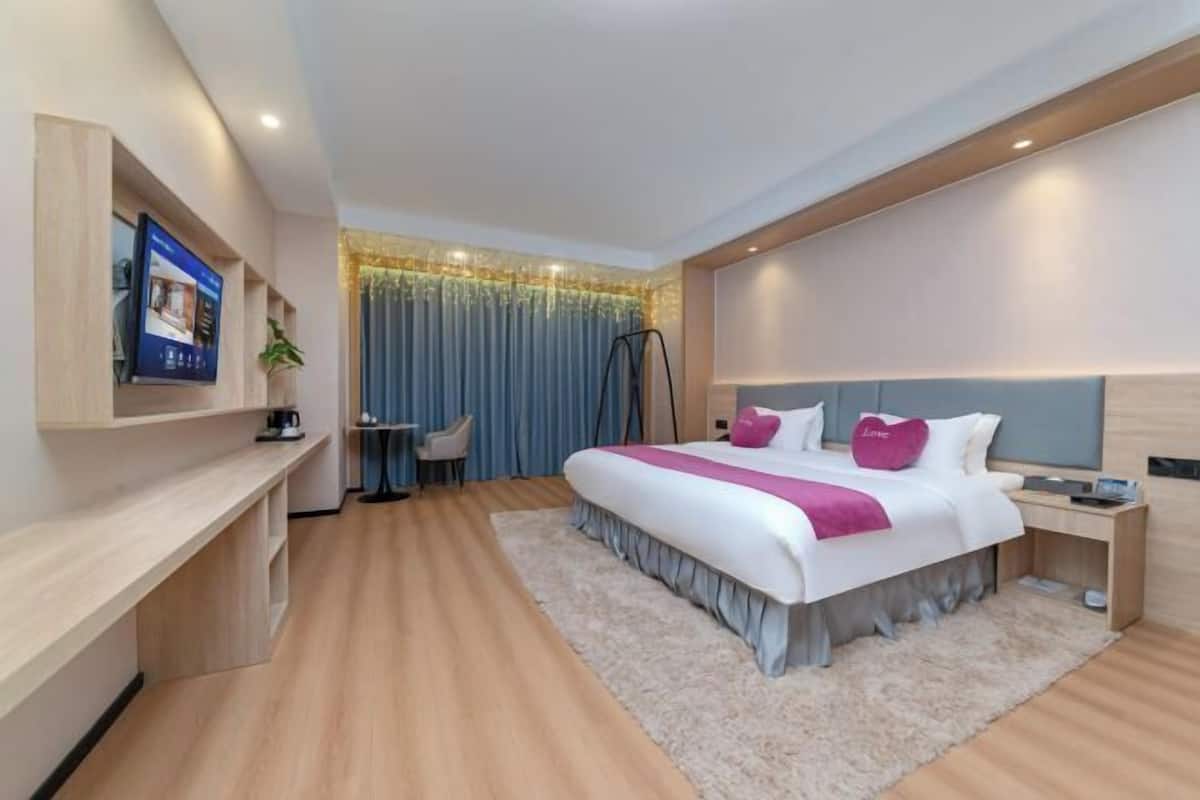 Une chambre d’hôtel moderne dotée d’un grand lit, d’un bureau, d’une télévision et offrant une vue sur la ville.