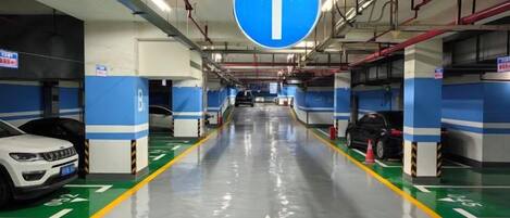 A parking garage with directional arrows on the floor and walls, indicating the flow of traffic.