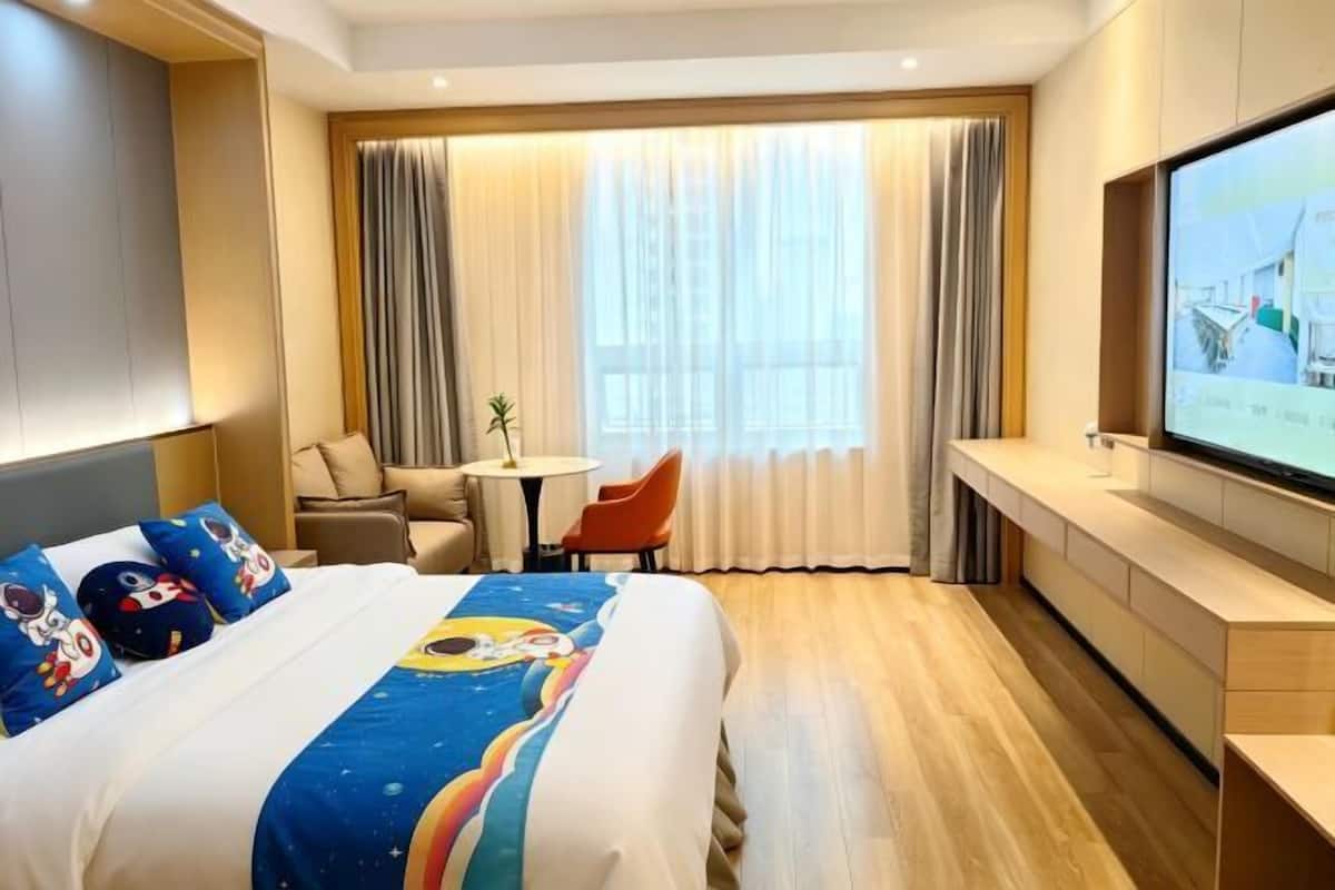 Une chambre d’hôtel avec un lit, une télévision, un bureau et une chaise.