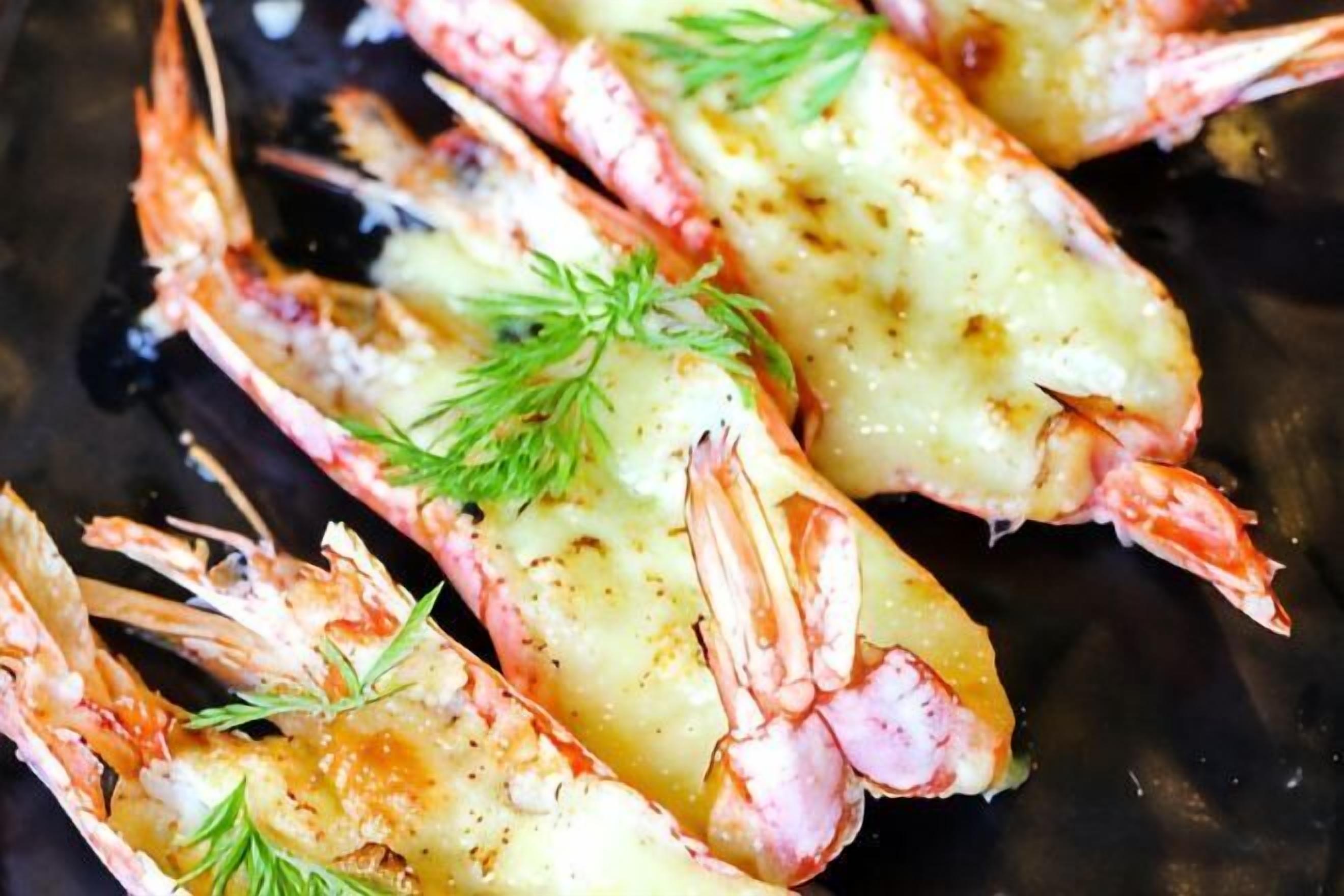 Cooked seafood, possibly shrimp, garnished with herbs.