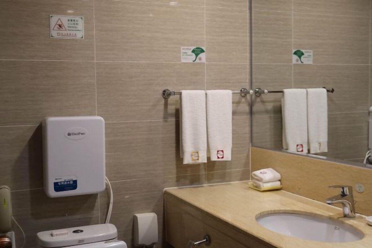 A bathroom with a toilet, sink, and towel rack.