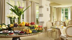 A breakfast buffet with a variety of fruits, pastries, and flowers. - Villa Roma Imperiale (Forte dei Marmi)