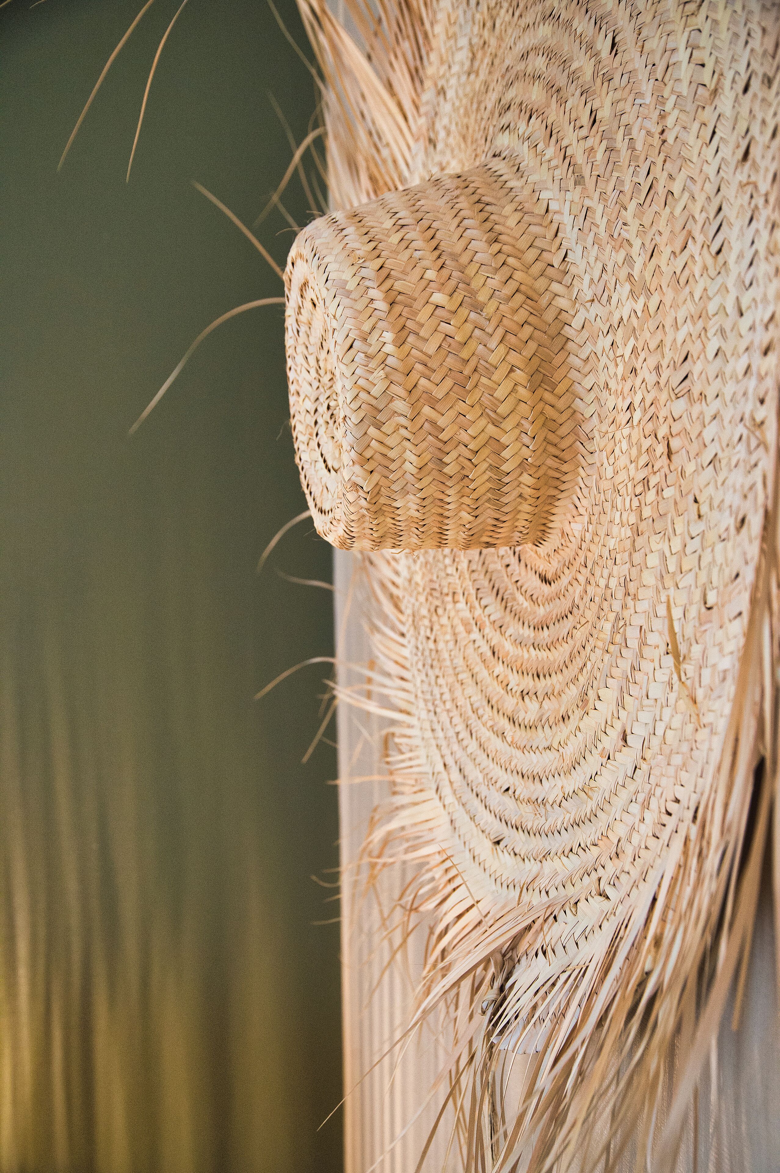 A close-up of a woven straw hat with a textured pattern.