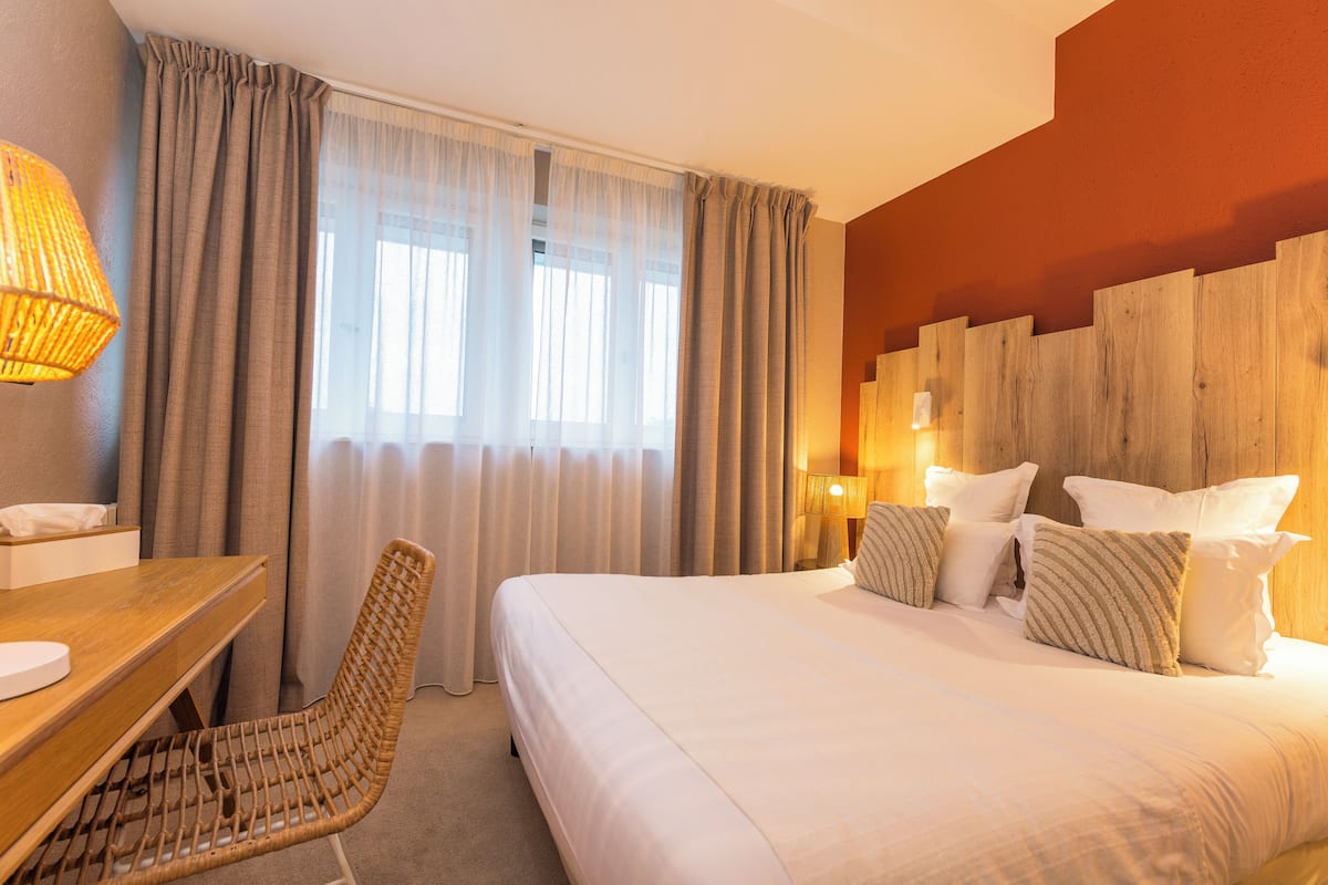 Ein Hotelzimmer mit einem Bett, einem Schreibtisch und einem Sessel.
