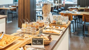 Un bufé de desayuno con diversas opciones de comida y una estación de café.