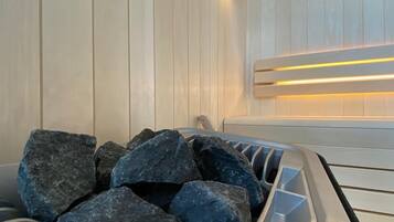 Una sauna con paredes de madera y un banco, que contiene varias rocas grandes.