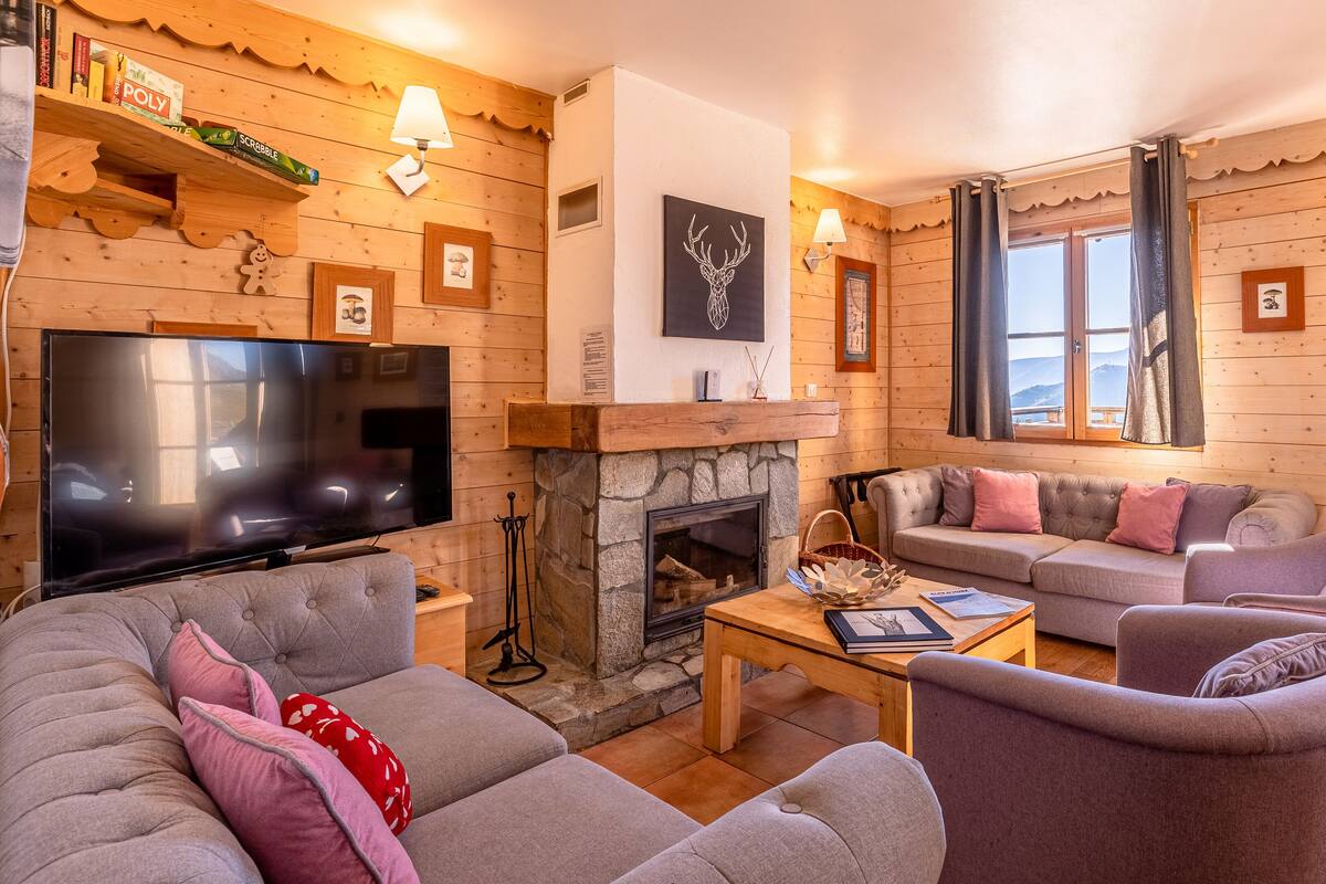 Una sala de estar acogedora con chimenea, televisor de pantalla plana y un área de estar cómoda con sofás y sillones.