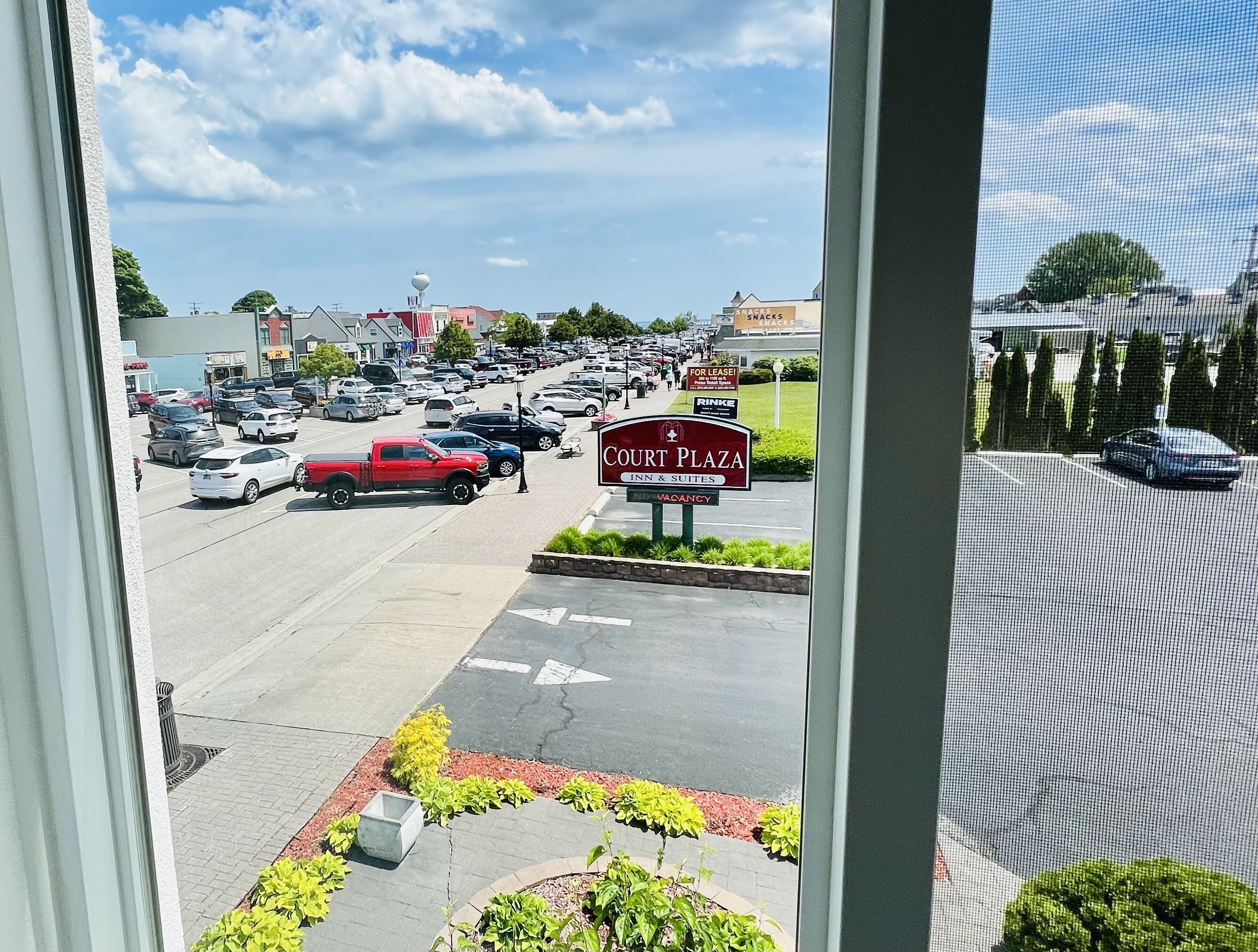 A view of a parking lot with a sign for Court Plaza Inn & Suites.