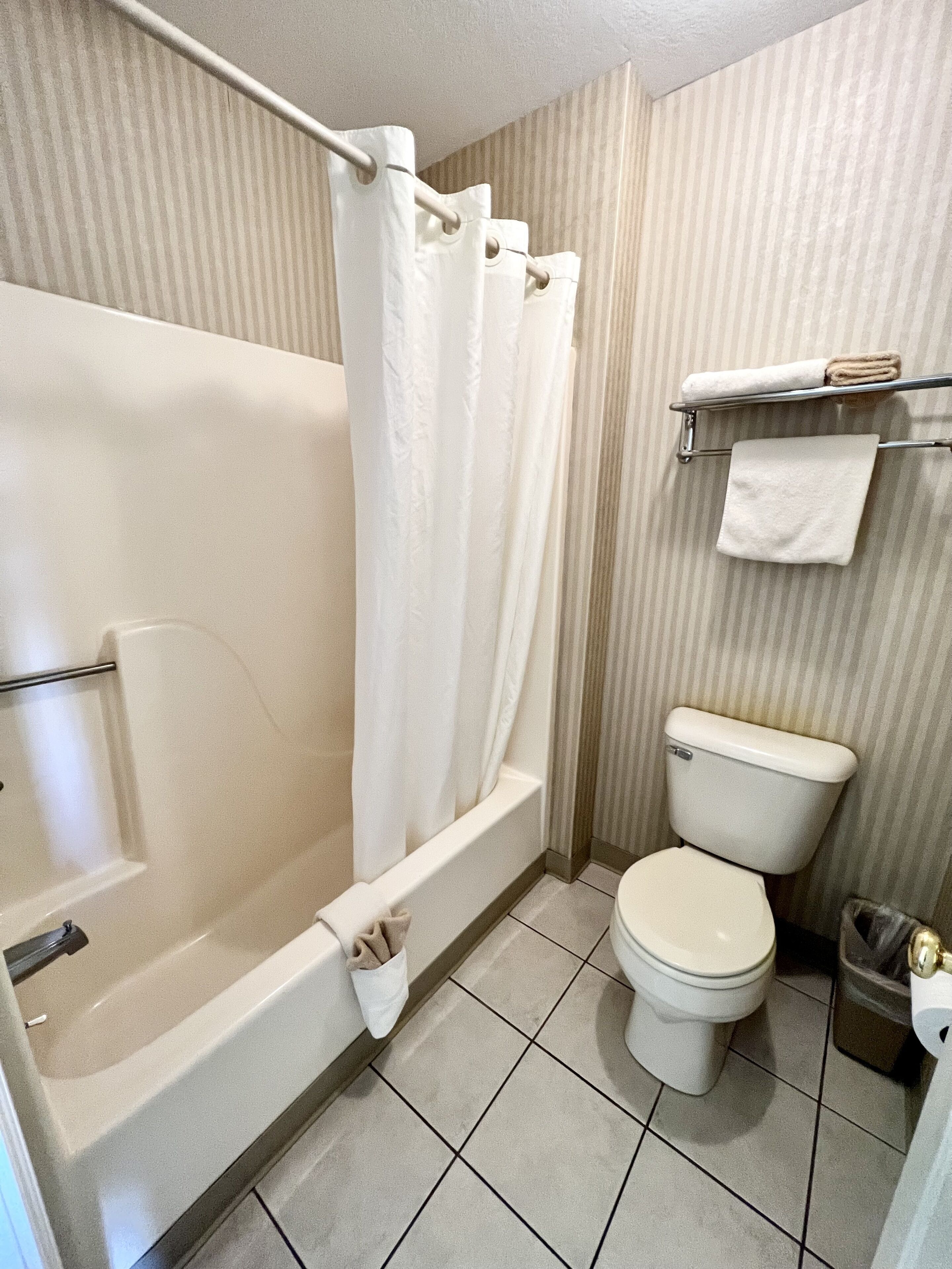 Ein Badezimmer mit Badewanne, Toilette und Handtuchhalter.