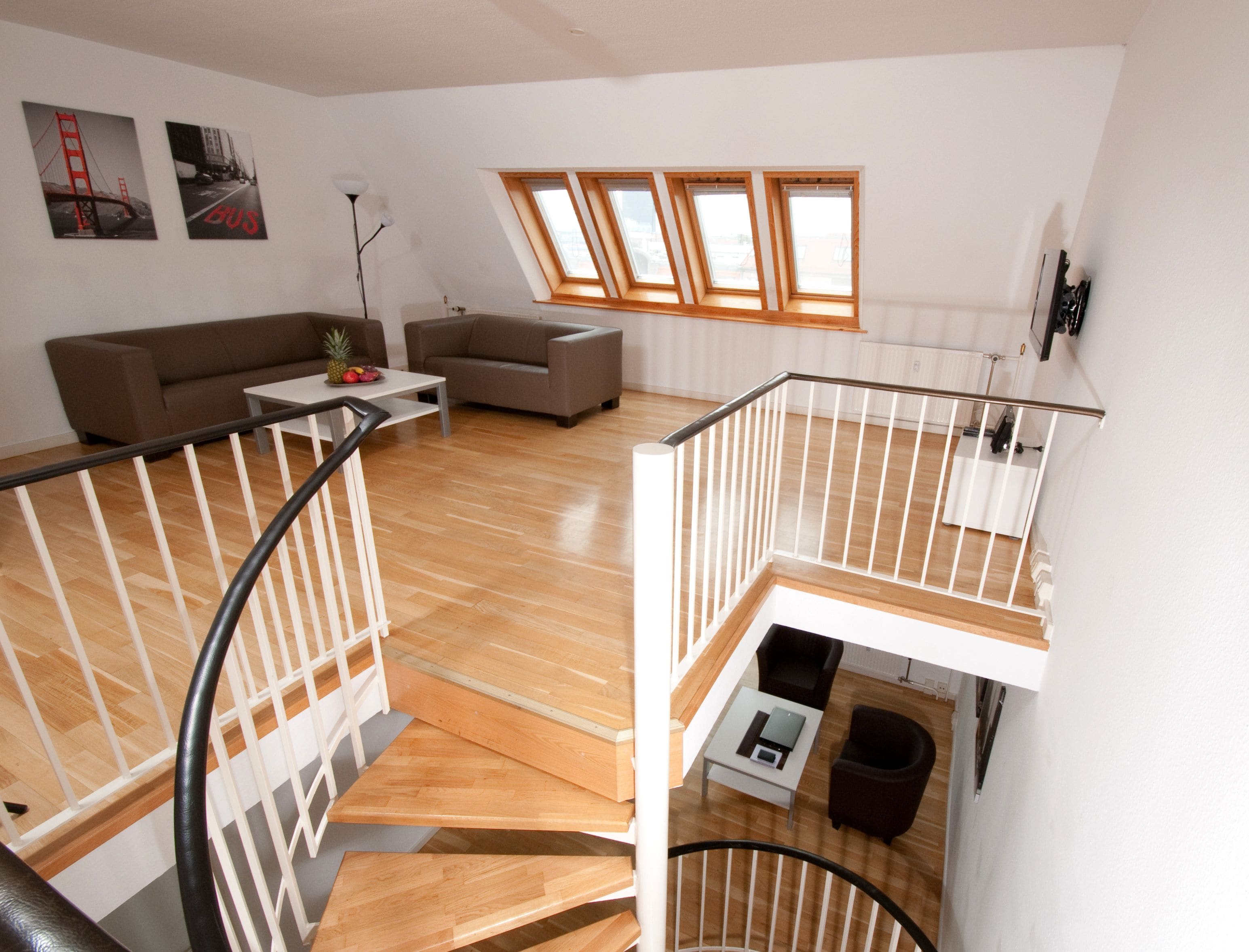 A spacious living area with a sofa, a coffee table, and a staircase leading to an upper level.