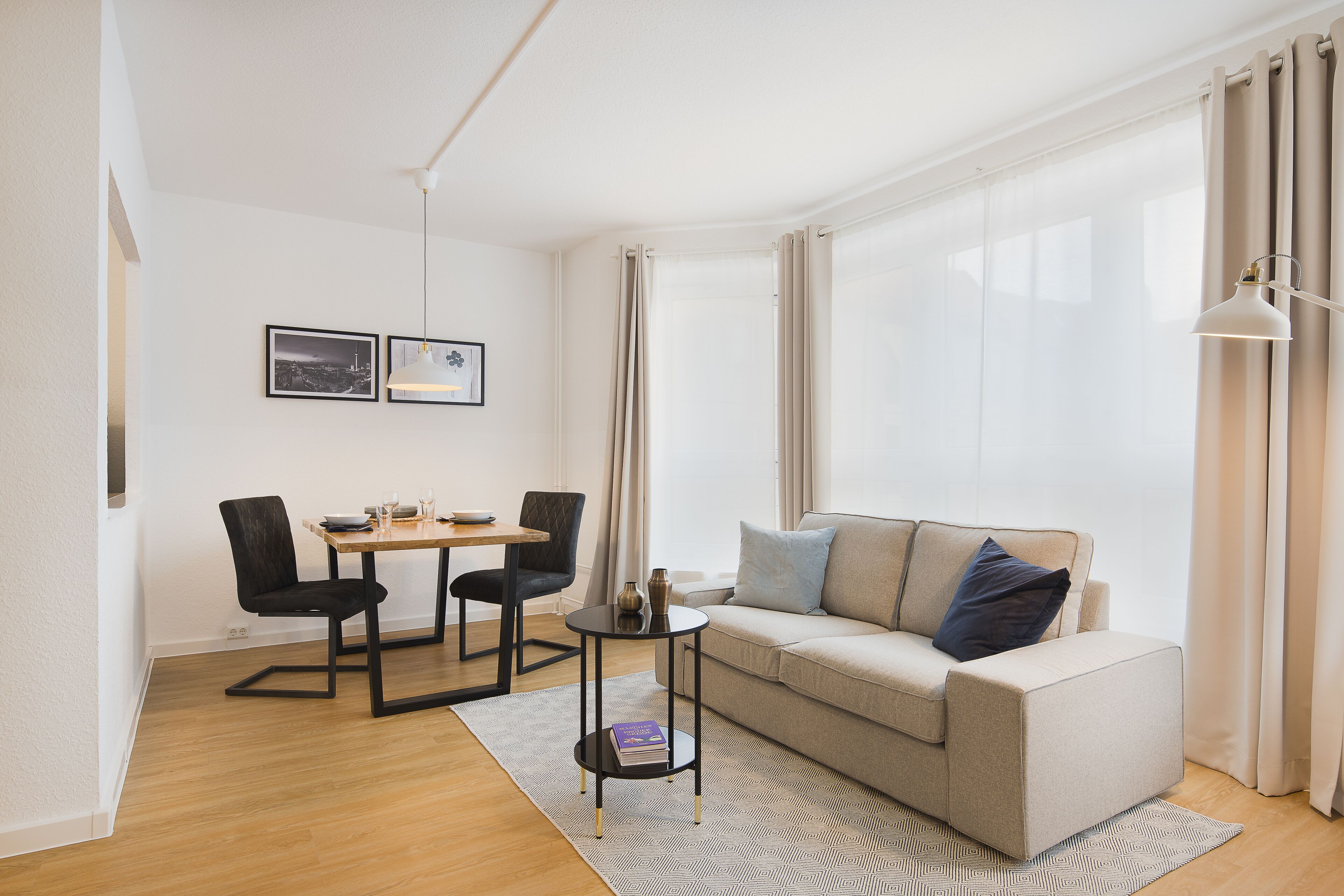 Una sala de estar moderna con un sofá, dos sillones, una mesita y una lámpara.