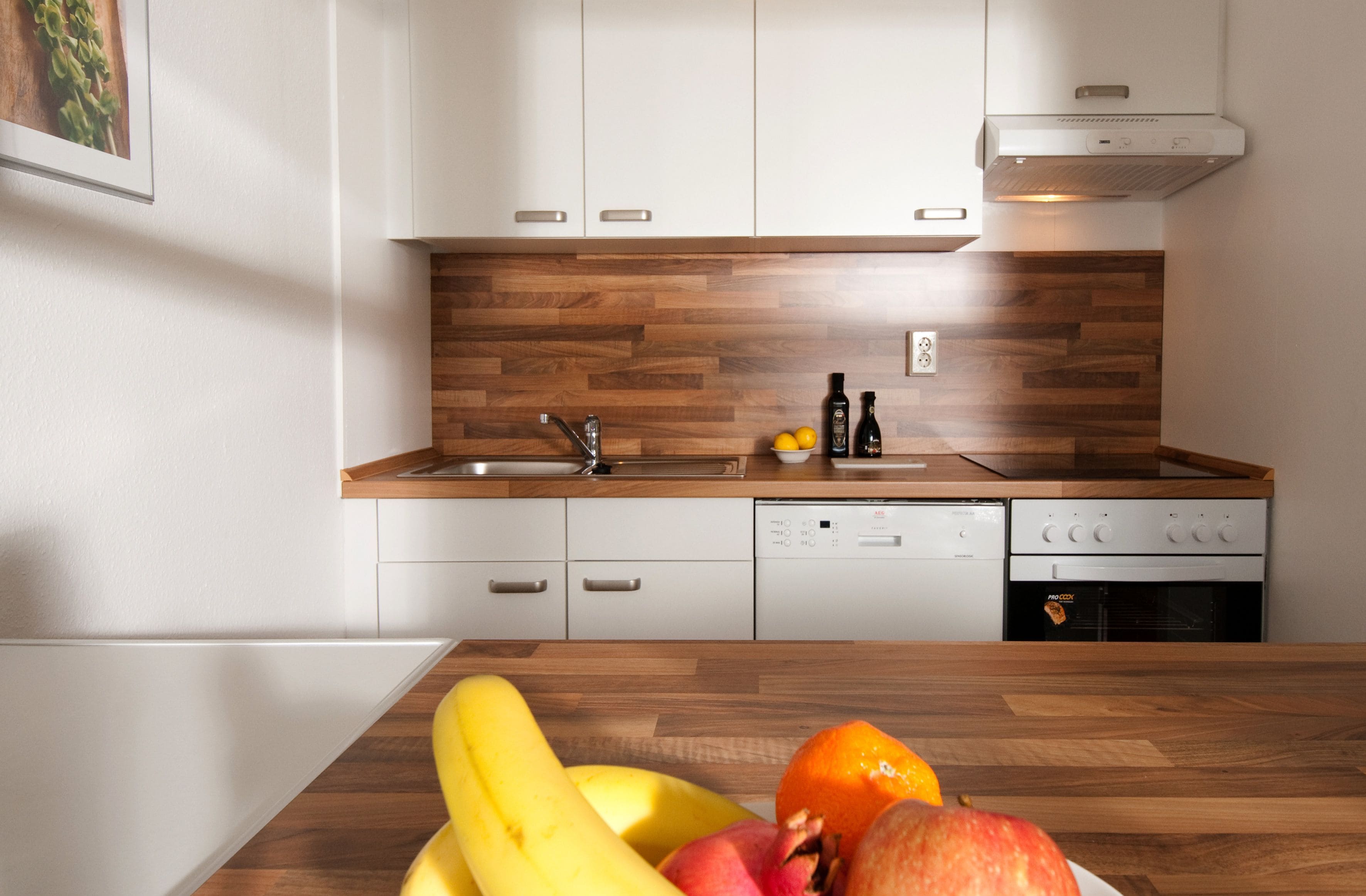 A modern kitchen with wooden cabinetry, a stainless steel sink, and a built-in oven.
