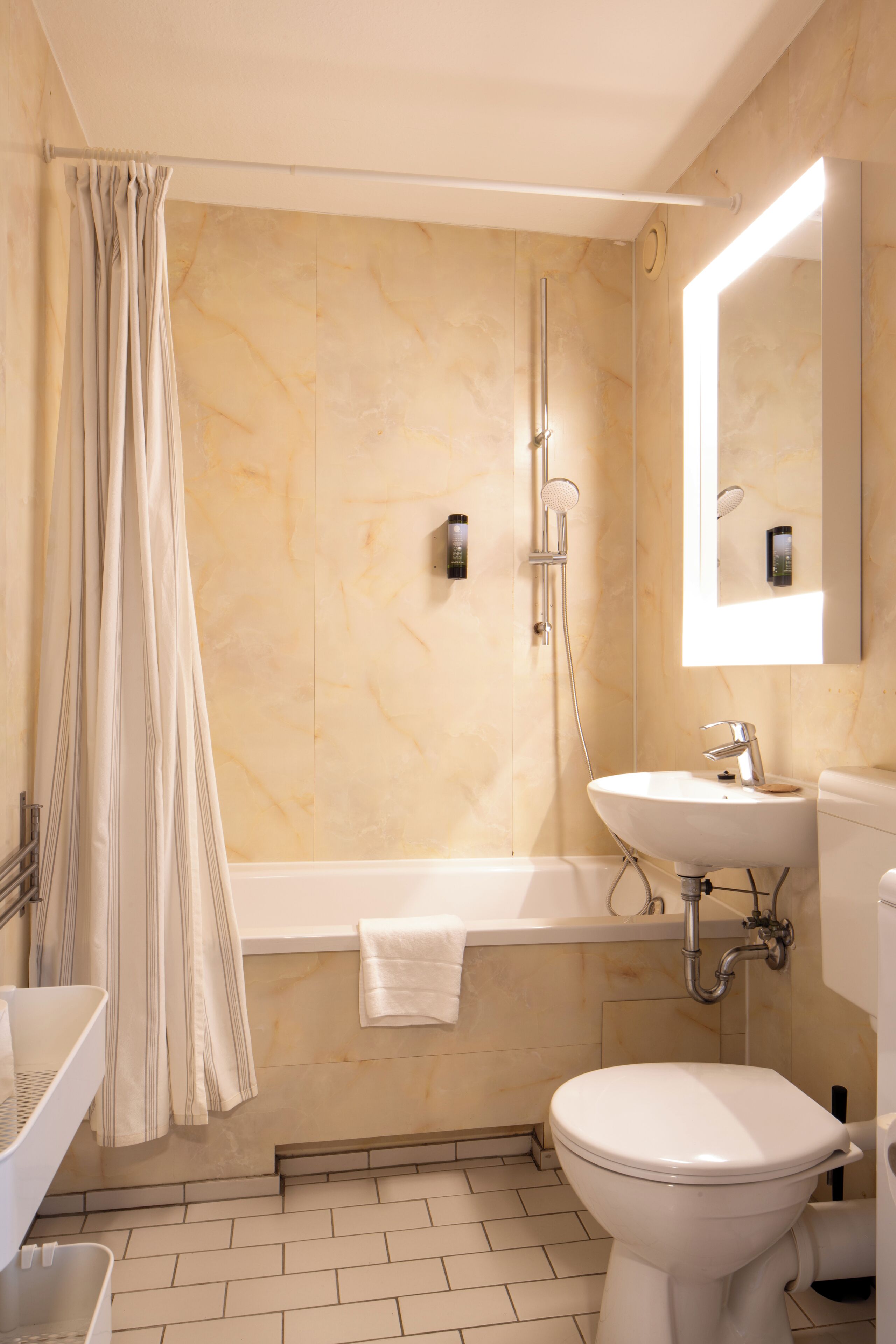 A bathroom with a bathtub, toilet, sink, and shower.