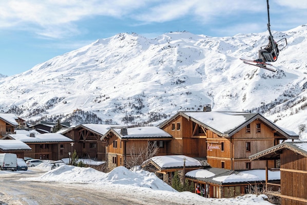 Un edificio de estilo chalet de madera con un letrero que dice "Balmabia" en un pueblo de montaña nevado.