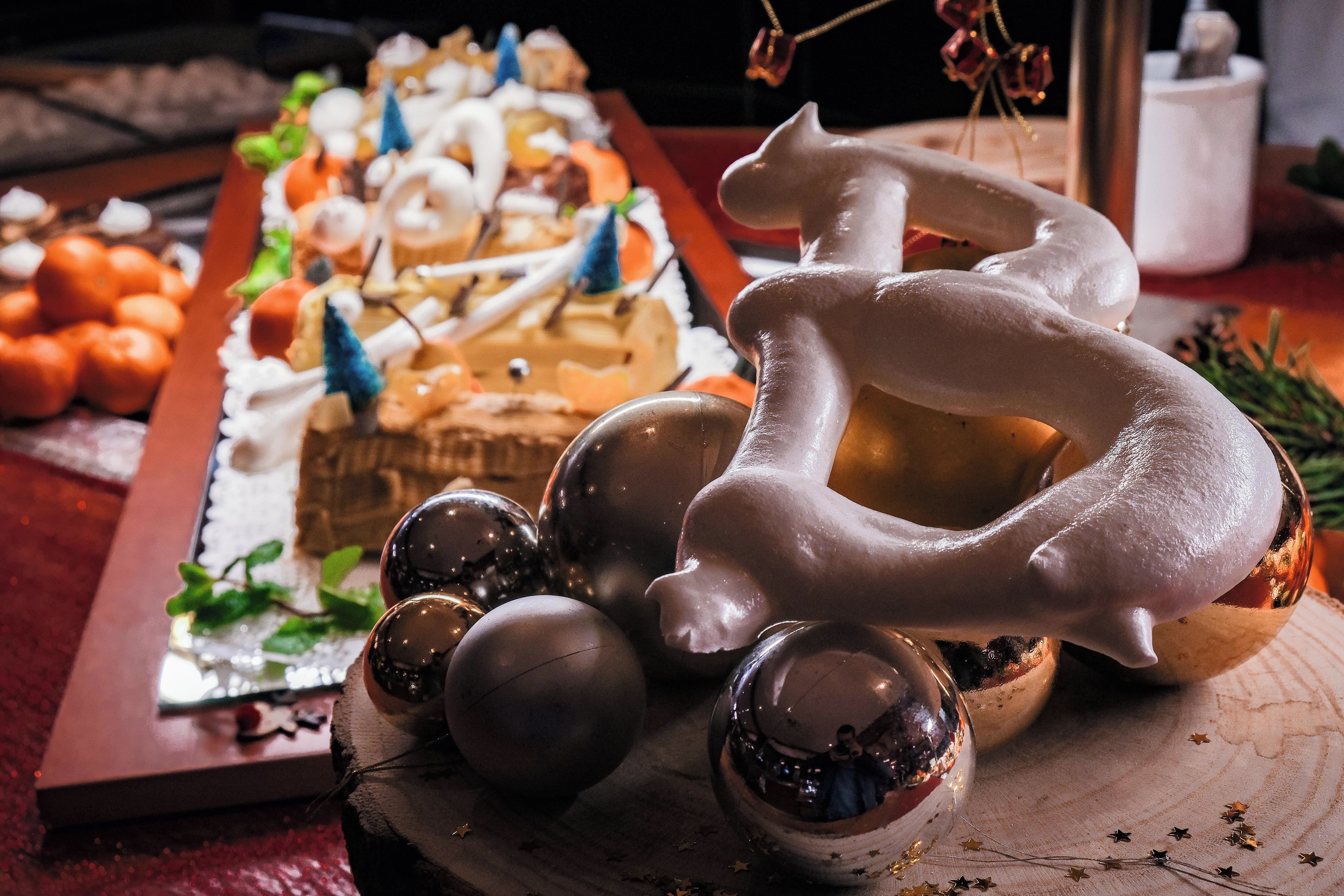 Une table de desserts avec divers types de sucreries et une sculpture de glace décorative.